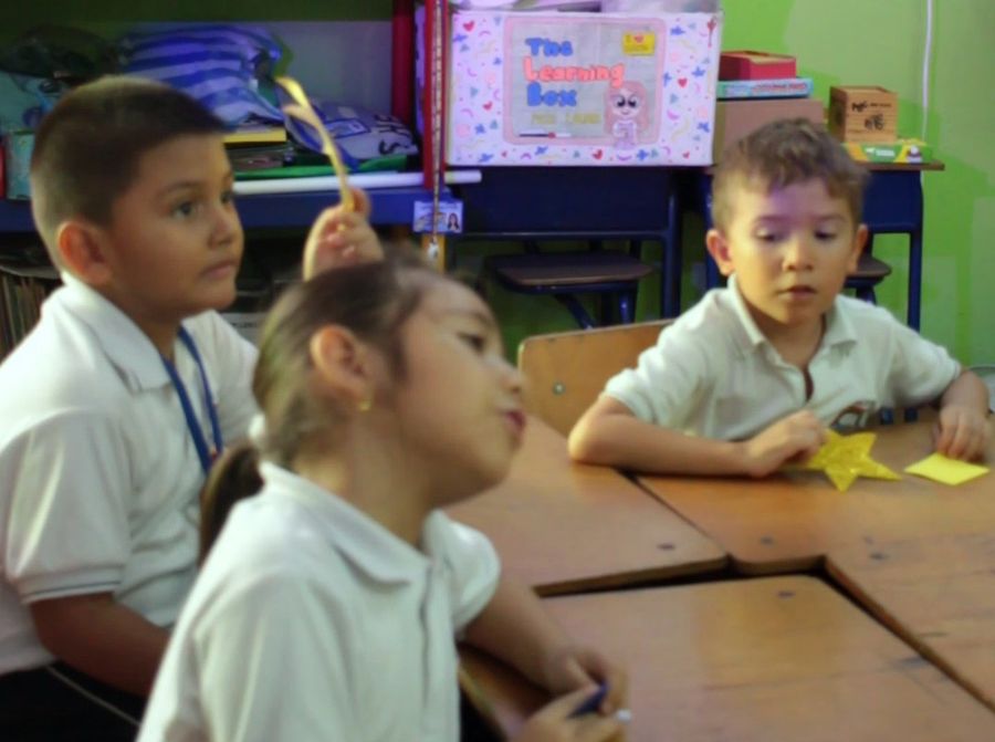 Niños de primaria participando en clase con estrellas de papel