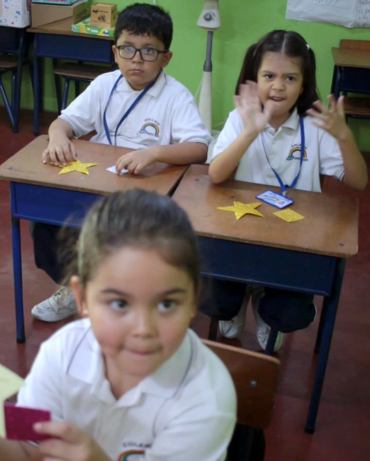 Niña mostrando su estrella de papel en clase