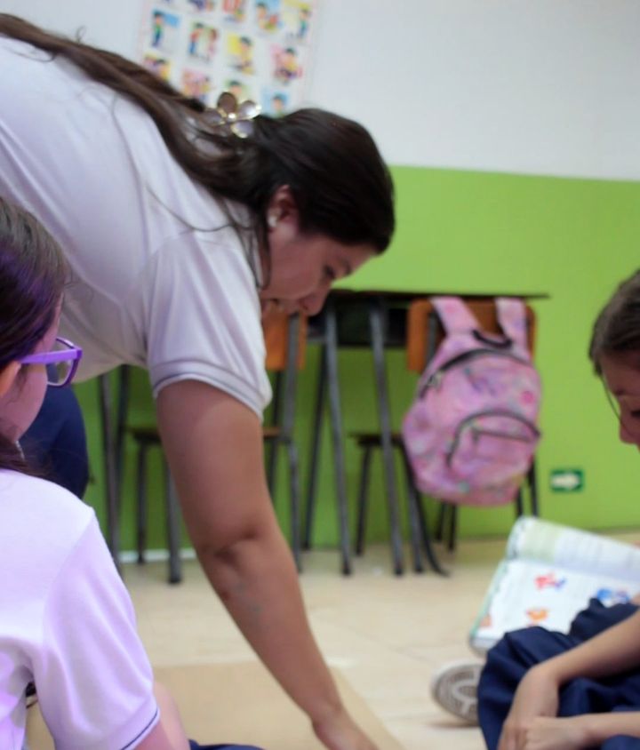Profesora ayudando a una estudiante en una actividad